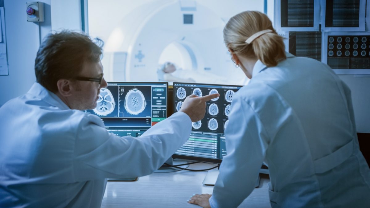 Two physicians examining an MRI screen.