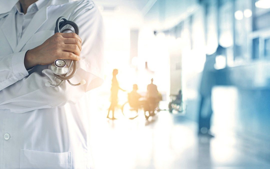 Doctor holding a stethoscope in a hospital hallway